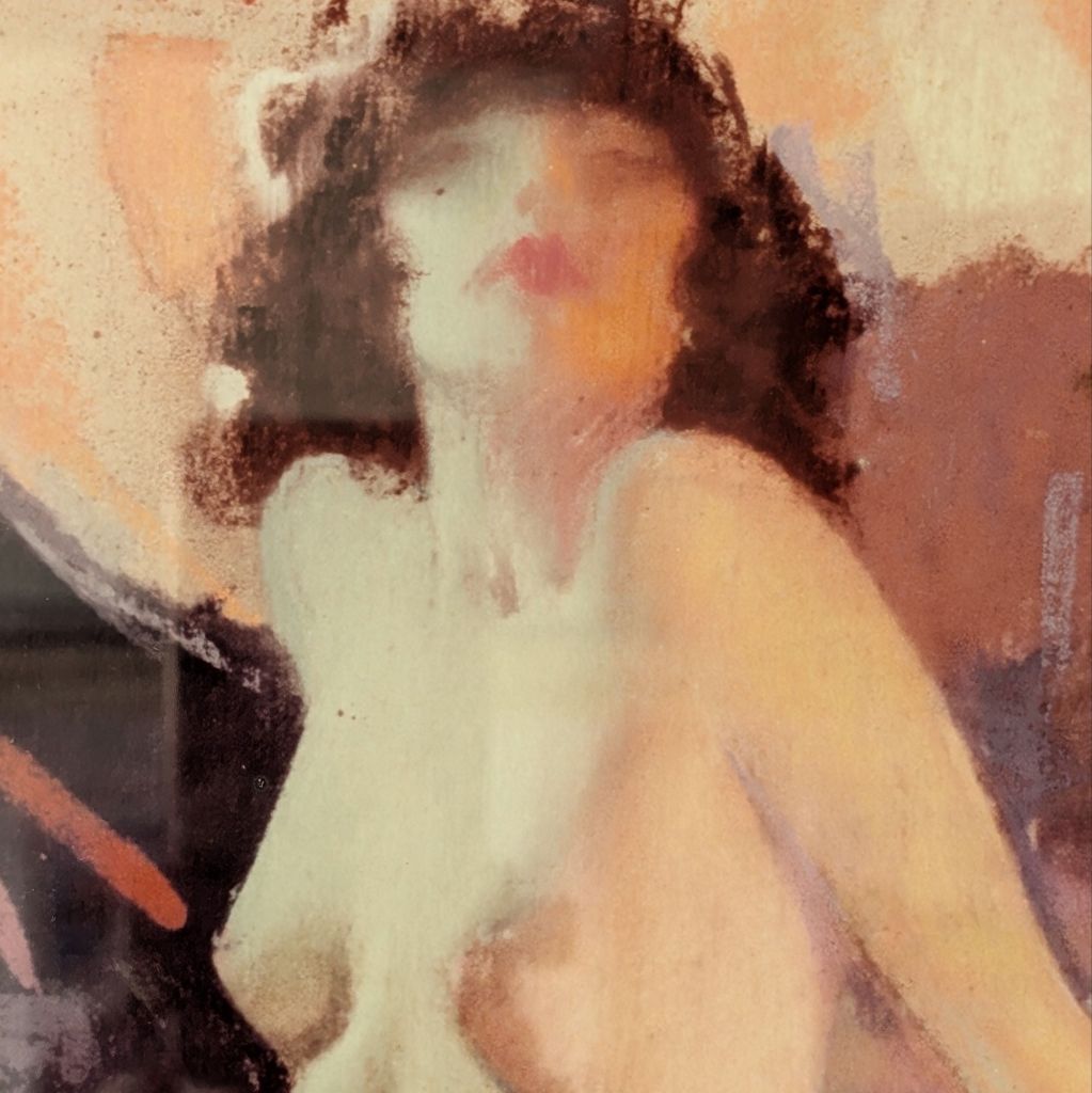 Close up of the face on print of a nude woman seated on fabric with her chin raised